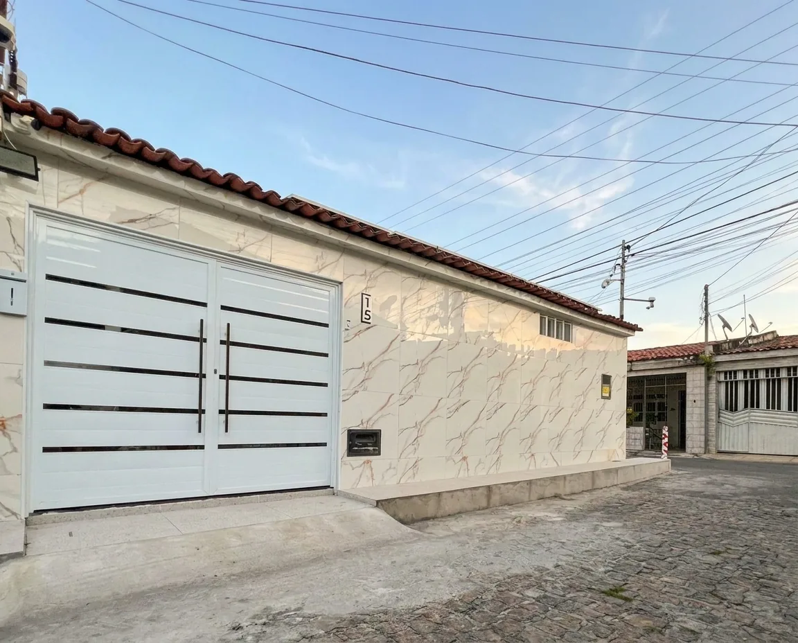 Fachada do salão Danny Beauty: portão branco e parede de porcelanato marmorizado com o número 15, vista da rua